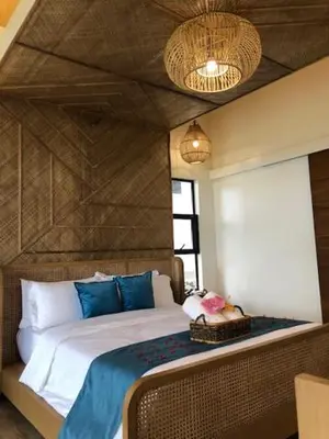 a bedroom with a large bed with blue pillows at Island Garden Beach Resort in Manila