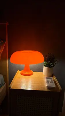 an orange lamp on a wooden table with a plant at Rosé Nights Luxury in Manila