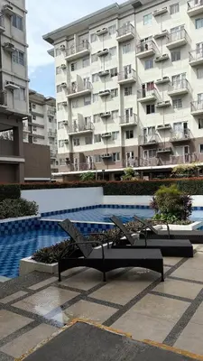 a swimming pool in front of a large apartment building at Rosé Nights Luxury in Manila