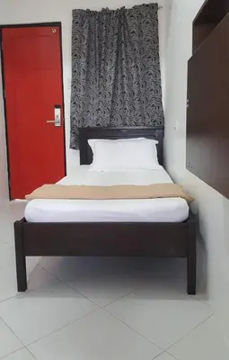 a bed with a red door in a room at ChaerinCL in Manila