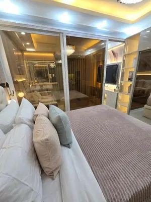 a large white bed with pillows in a bedroom at Royal Suites at Shore Residences near SM MOA and Airport in Manila