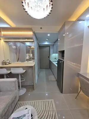 a kitchen and living room with a chandelier at Royal Suites at Shore Residences near SM MOA and Airport in Manila