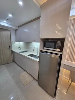 a kitchen with a stainless steel refrigerator and a microwave at Royal Suites at Shore Residences near SM MOA and Airport in Manila