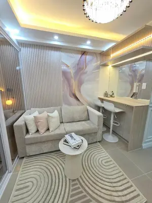 a living room with a couch and a desk at Royal Suites at Shore Residences near SM MOA and Airport in Manila