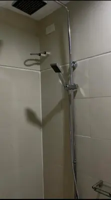 a shower with a glass door in a bathroom at Calm Corner near Mall of Asia in Manila