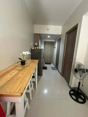 a kitchen with a wooden table and a fan at Calm Corner near Mall of Asia in Manila
