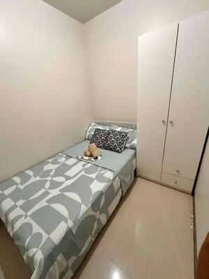 a small bedroom with a bed and a cabinet at Calm Corner near Mall of Asia in Manila
