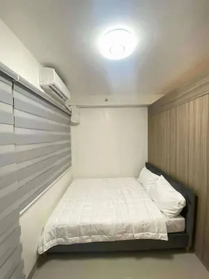 a small bedroom with a white bed in it at Staycation Marcos Residence in Manila