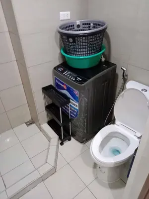 a bathroom with a toilet and a basket on top at Staycation Marcos Residence in Manila