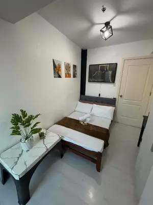 a small room with two beds and a table at Azure Destiny's Suites 1214 in Manila