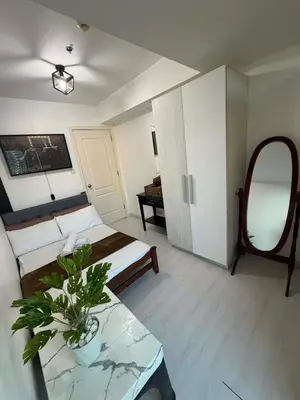a living room with a bed and a table with a plant at Azure Destiny's Suites 1214 in Manila