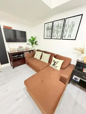 a living room with a brown couch and a flat screen tv at Azure Destiny's Suites 1214 in Manila