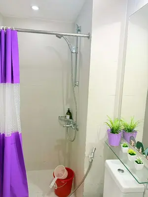 a bathroom with a shower with a purple shower curtain at Azure Destiny's Suites 1214 in Manila