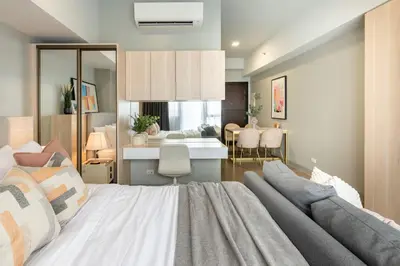 a bedroom with a large bed and a dining room at Uptown BGC Condo in Manila