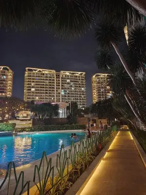 a swimming pool at night with tall buildings at Azure staycation near Airport beside SM Bicutan in Manila