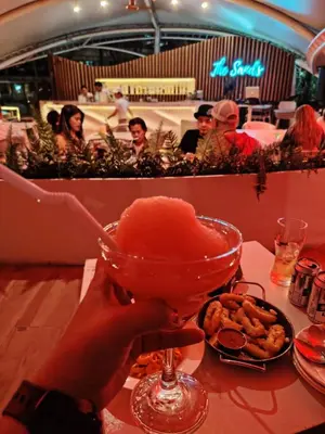 a person holding a drink in a martini glass at Azure staycation near Airport beside SM Bicutan in Manila