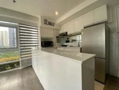 a kitchen with a large white counter and a refrigerator at Stylish Stay in BGC 5th Ave with Free Parking in Manila