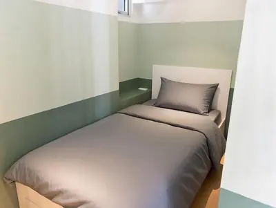 a small bedroom with a bed in the corner at Stylish Stay in BGC 5th Ave with Free Parking in Manila