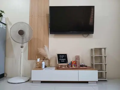 a living room with a fan and a tv on a wall at 1BR Cozy Townhouse - AC in room only in General Trias