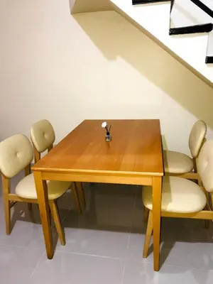a wooden table with chairs and a vase on it at 1BR Cozy Townhouse - AC in room only in General Trias