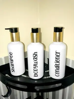 three white bottles on a black shelf at 1BR Cozy Townhouse - AC in room only in General Trias