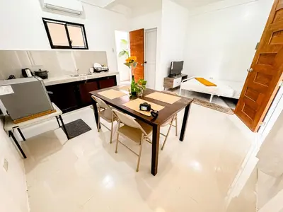 a kitchen and living room with a wooden table and a dining room at LAD Private Reosrt in Dasmariñas