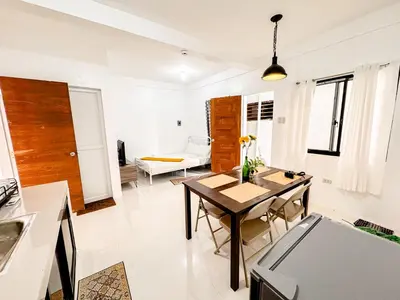a kitchen and living room with a table and chairs at LAD Private Reosrt in Dasmariñas
