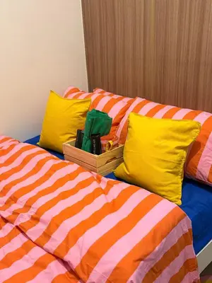 two beds with colorful sheets and yellow pillows at Euphoria Suites Shore 2 Tower 1 Residences in Manila