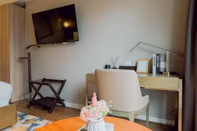 a room with a desk and a white chair and a table at Primo Espacio at Hotel Residences Acqua in Manila