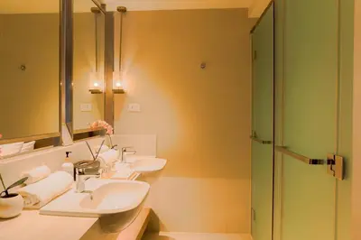 a bathroom with two sinks and a shower at Primo Espacio at Hotel Residences Acqua in Manila