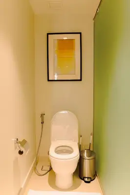 a bathroom with a toilet with a picture on the wall at Primo Espacio at Hotel Residences Acqua in Manila