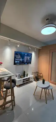 a living room with two tables and a flat screen tv at Near Airport Malls shore 3 Mall of Asia in Manila