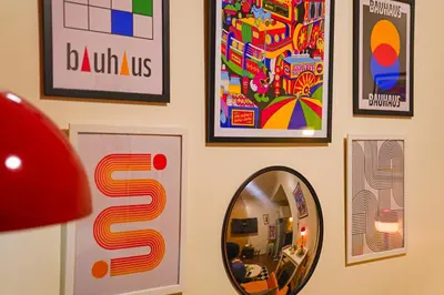 a wall with pictures and a mirror on a wall at Airhaus Studio in Manila