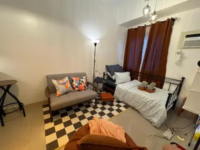 a living room with a bed and a chair at Katya Suite in Pasong Bayog
