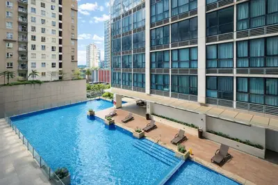 an overhead view of a swimming pool in front of a building at Modern 1BR One Uptown Residence Walk to UptownMall in Manila