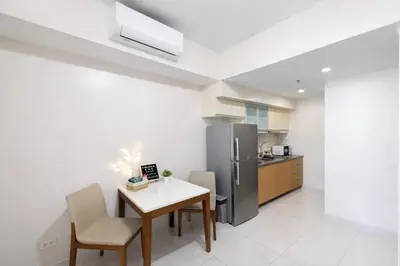 a kitchen with a table and chairs and a refrigerator at Modern 1BR One Uptown Residence Walk to UptownMall in Manila