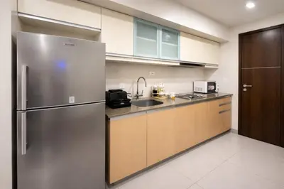 a kitchen with a stainless steel refrigerator and cabinets at Modern 1BR One Uptown Residence Walk to UptownMall in Manila
