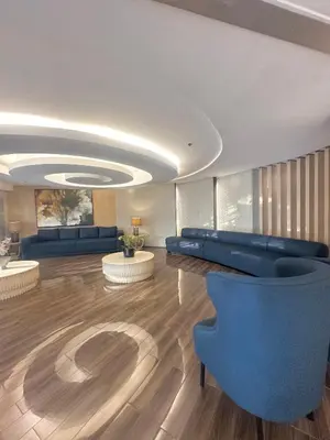 a living room with a blue couch and chairs at Shell Residences MOA by Seph in Manila