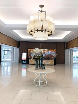 a large lobby with a table and a chandelier at Shell Residences MOA by Seph in Manila