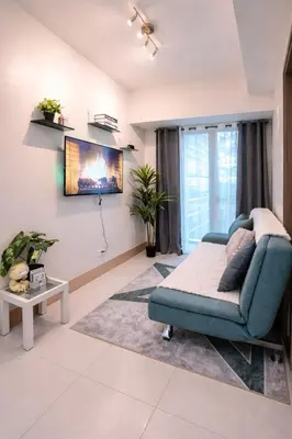 a living room with a couch and a tv at Cozy Unit at Shore 3 Residences Tower 4 near MOA in Manila