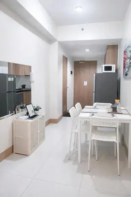 a kitchen with a white table and white chairs at Cozy Unit at Shore 3 Residences Tower 4 near MOA in Manila