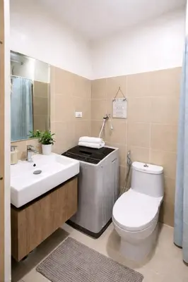 a bathroom with a toilet and a sink at Cozy Unit at Shore 3 Residences Tower 4 near MOA in Manila
