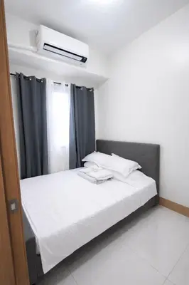 a bedroom with a bed with a black curtain at Cozy Unit at Shore 3 Residences Tower 4 near MOA in Manila