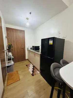 a kitchen with a black refrigerator and a table at Casa Bella Retreat in Manila