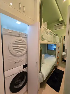 a small room with a washing machine and a bunk bed at Modern 4BR in Central BGC Walk to Shangrila and Ascot in Manila