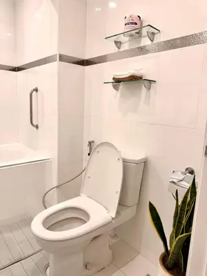 a white bathroom with a toilet and a sink at Modern 4BR in Central BGC Walk to Shangrila and Ascot in Manila