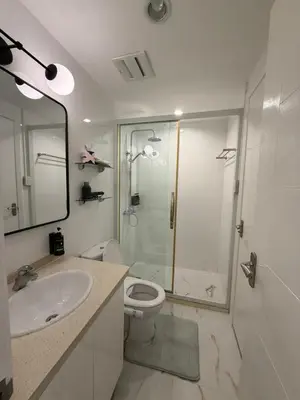 a bathroom with a shower and a toilet and a sink at Modern 4BR in Central BGC Walk to Shangrila and Ascot in Manila
