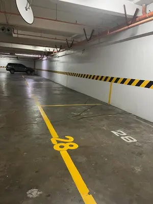 a parking garage with a pair of scissors painted on the floor at Modern 4BR in Central BGC Walk to Shangrila and Ascot in Manila