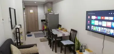 a living room with a table and a tv on a wall at Vienna's Accomodation in Manila