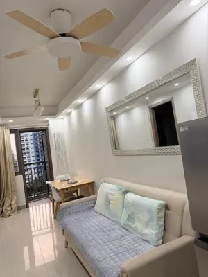 a living room with a couch and a mirror at S residence tower 3 Friendship family hotel in Manila